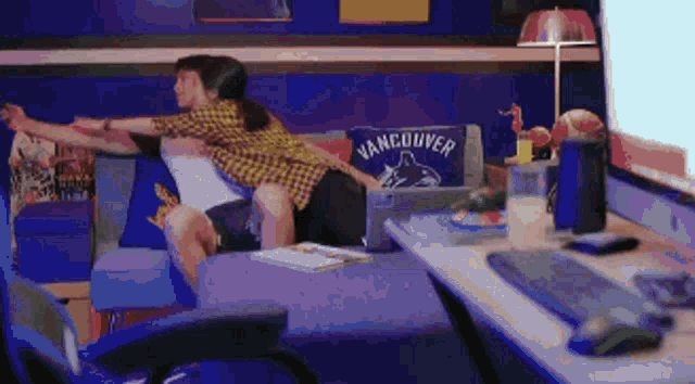 a man and a woman are hugging on a couch with a vancouver pillow on it .