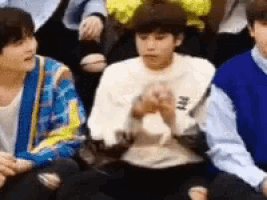 a group of young men are sitting next to each other .