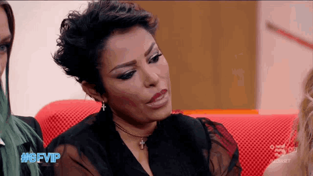 a woman sitting on a red couch with the hashtag #gfvip on the bottom