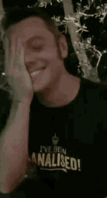 a man wearing a black shirt that says " i 've been analysed "
