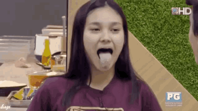 a woman is sticking her tongue out while wearing a purple shirt that says pg on it
