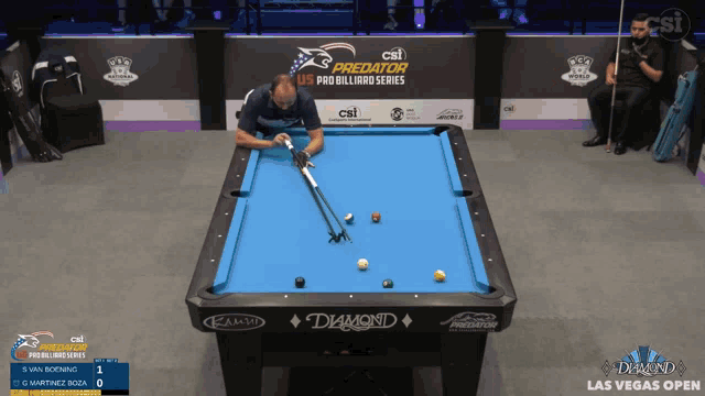 a man is playing pool in front of a sign that says predator