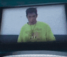 a man in a neon green shirt with a necklace that says 600 on it