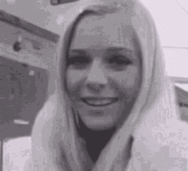 a black and white photo of a smiling blonde woman .