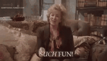 a woman is sitting on a couch with her arms outstretched and the words `` such fun '' written on the screen .