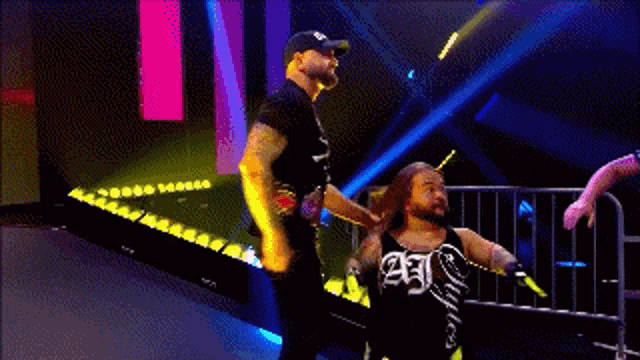 a group of wrestlers are standing on a ramp with a referee standing behind them