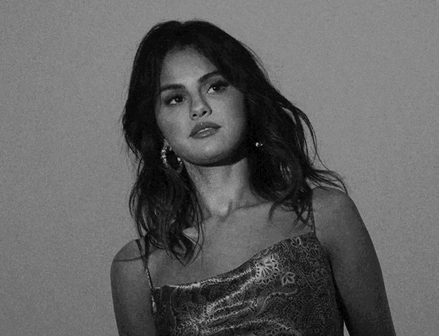 a black and white photo of a woman wearing a snake print dress