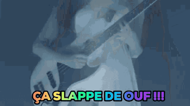a woman in a white dress is playing a guitar in a dark room with the words ca slappe de ouf !!! above her