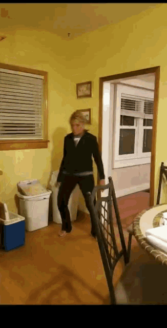 a woman standing on a chair in a living room
