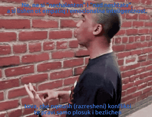a man standing in front of a red brick wall with the words ne ne si nechalaten i nad neshtita