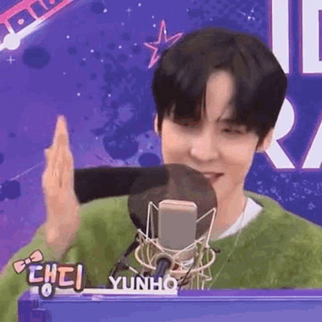 a young man is giving a high five to a microphone .