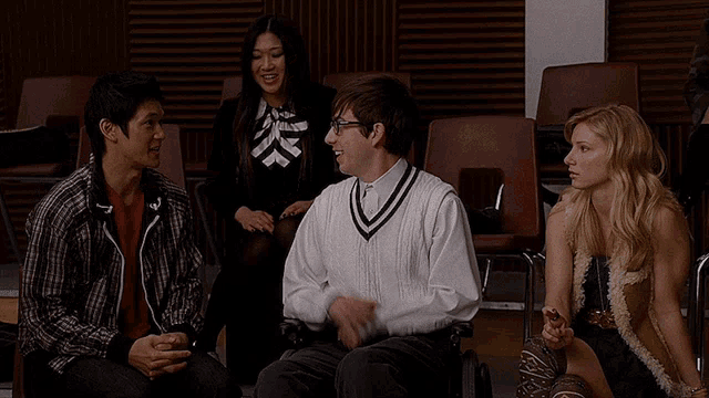 a group of people are sitting in chairs and one of them is a man in a wheelchair