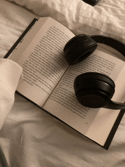 a pair of headphones sit on top of an open book