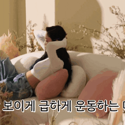 a woman is laying on a couch with korean writing on the bottom right
