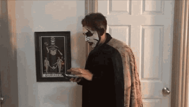 a man standing in front of a framed picture of a skeleton with the word diana on it