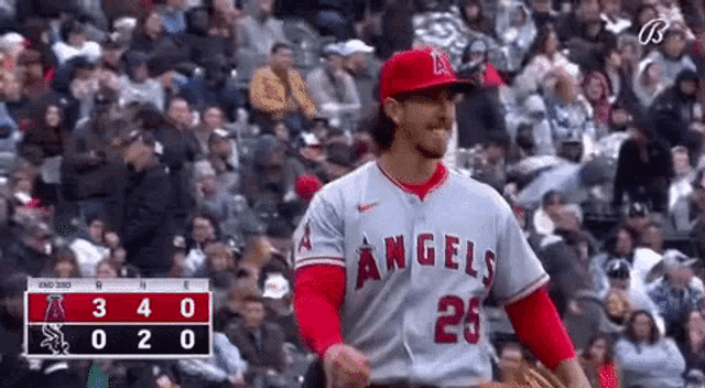 a baseball player for the angels is standing in front of a crowd of people .