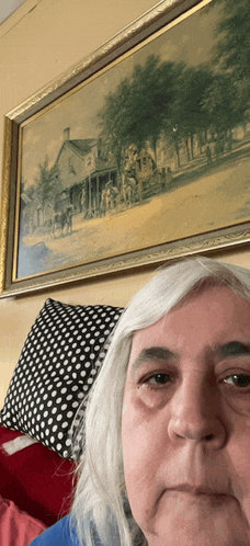 a woman takes a selfie in front of a painting