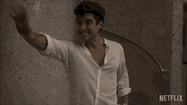 a man in a white shirt is waving in front of a netflix logo