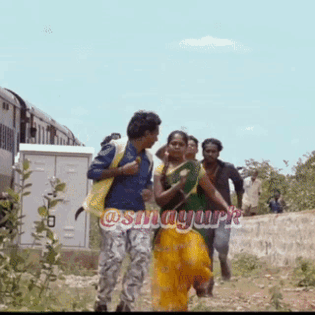 a group of people are walking down a dirt road with a train in the background and a watermark that says @snagurk