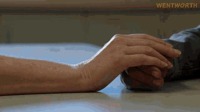 a person holding another person 's hand with wentworth on the bottom right