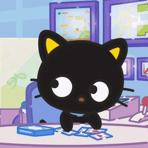 a black cat is playing a game of cards