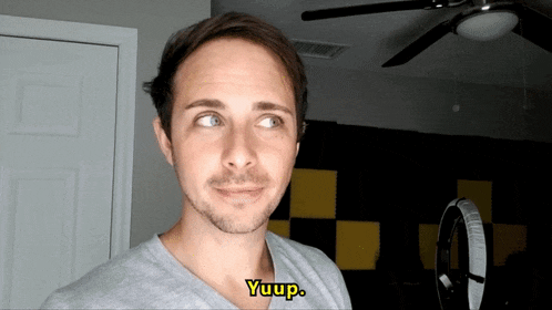 a man in a gray shirt says yup in yellow letters
