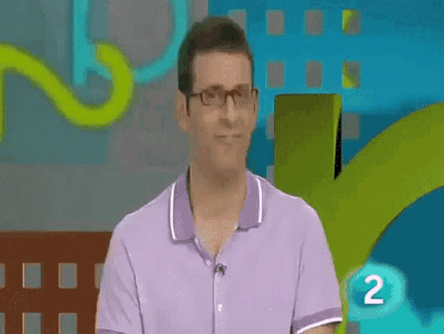 a man wearing glasses and a purple shirt is sitting in front of a screen with the number 2 on it