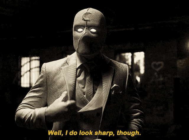 a man in a suit with a mask on says well i do look sharp though