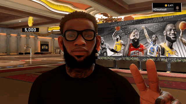 a man wearing glasses giving a peace sign in front of a basketball poster