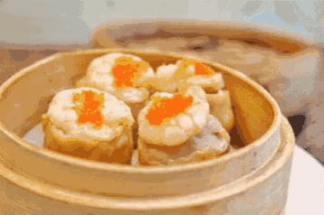 a person is holding a piece of food with chopsticks on a plate .
