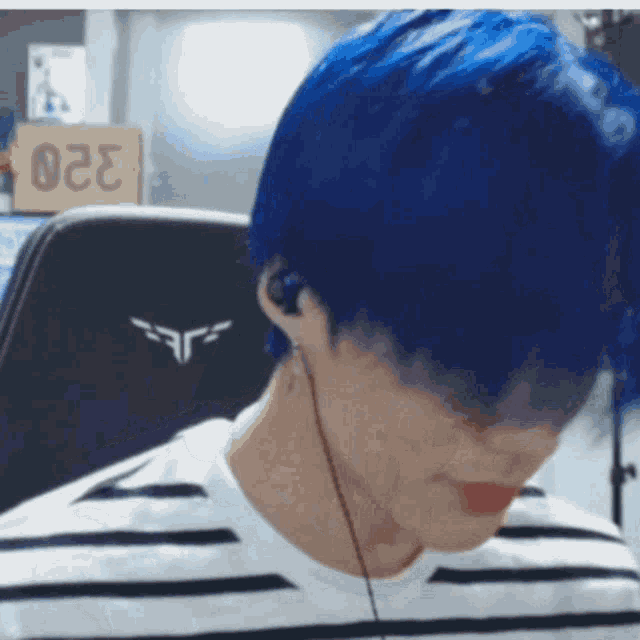 a man with blue hair is wearing a striped shirt