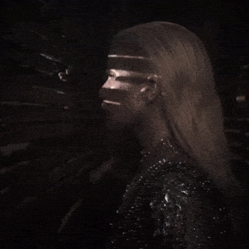 a woman in a black dress has a shadow projected onto her face
