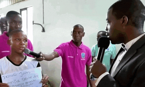 a man in a suit is holding a sign that says " sendo joar " on it
