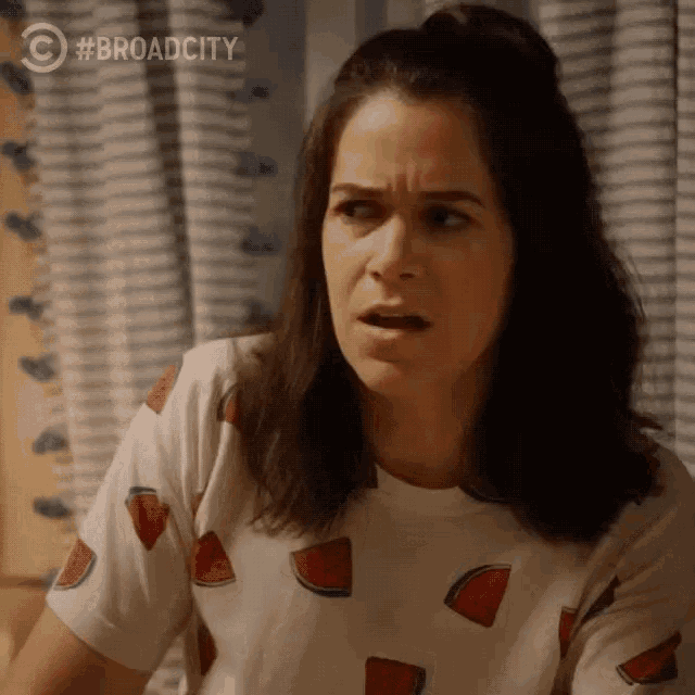 a woman wearing a watermelon t-shirt makes a surprised face