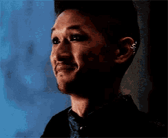a man with a piercing in his ear is smiling .