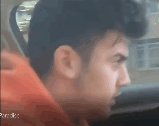 a close up of a man 's face in a car with the word paradise on the bottom