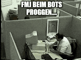 a man is sitting at a desk in an office with a computer .