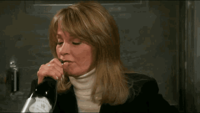 a woman drinking from a bottle with a label that says ' a ' on it