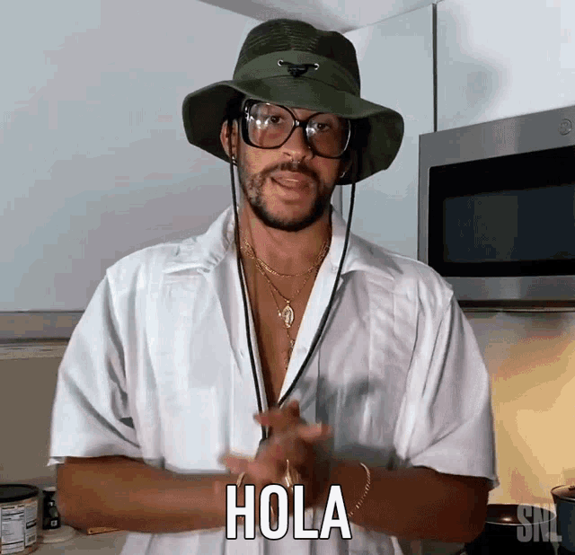 a man wearing a white shirt and a hat says hola