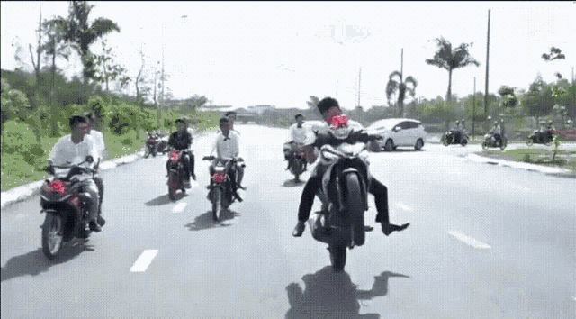 a man is doing a trick on a motorcycle on a road