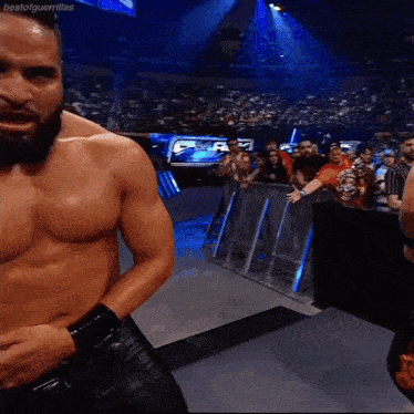 a shirtless wrestler is standing in front of a crowd with the hashtag bestofguerrillas