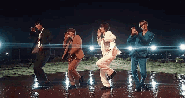 a group of men in suits are dancing together in the rain
