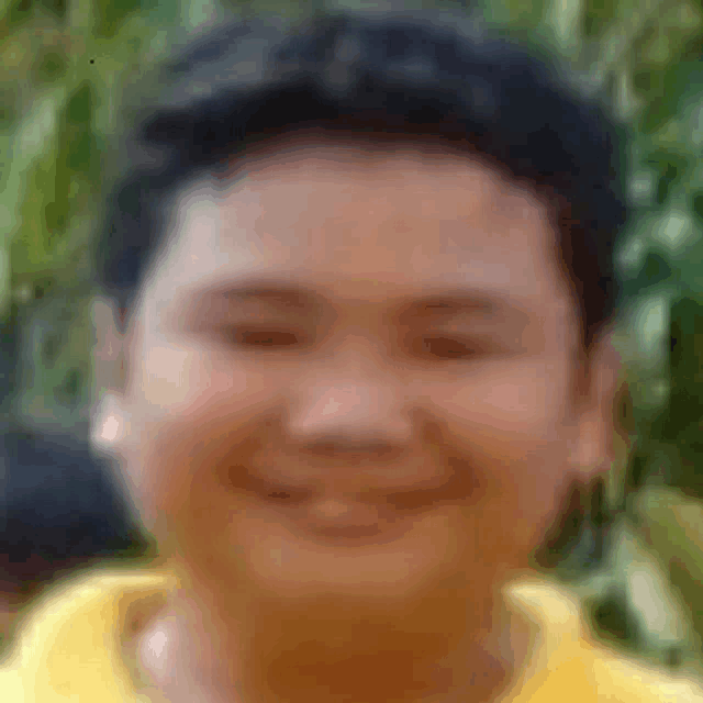 a close up of a man 's face with a yellow shirt on .