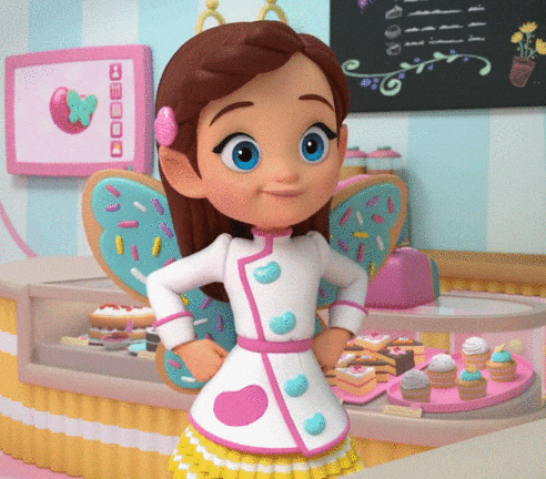 a little girl with a crown on her head is standing in front of a display case of cupcakes