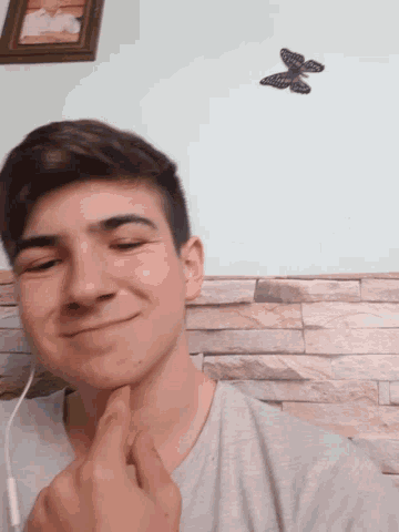 a young man with a butterfly on a wall behind him