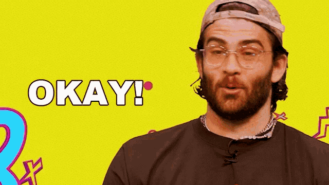 a man with glasses and a hat says okay on a yellow background