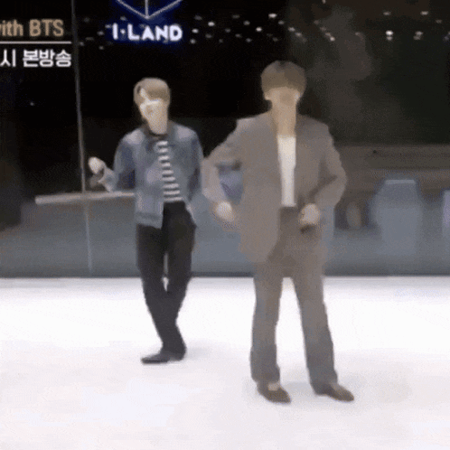 two men are dancing on a ice rink in front of a sign that says iland