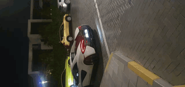 a row of cars are parked on a brick driveway