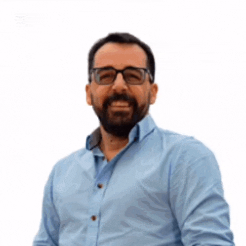a man with a beard wearing glasses and a blue shirt .