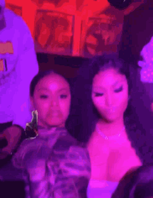 a couple of women standing next to each other in a room .